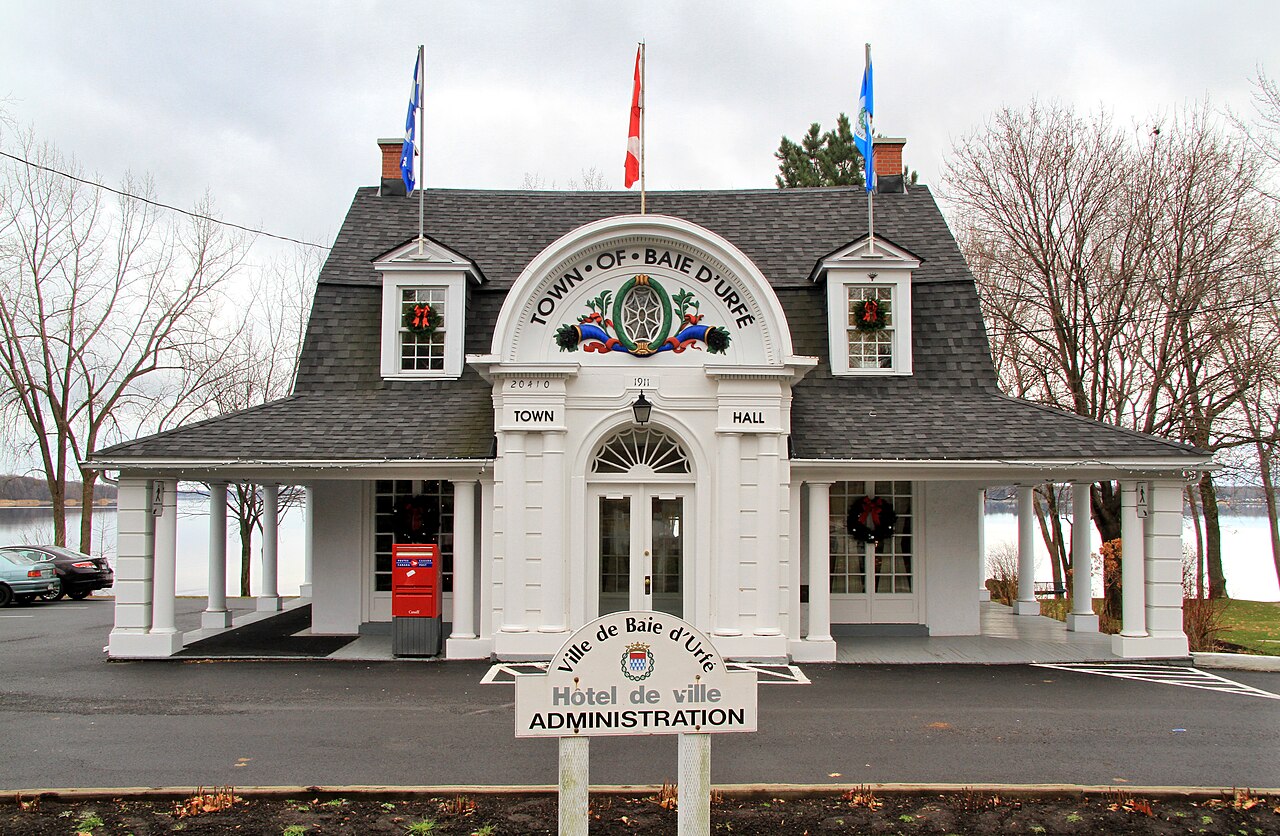 L'hôtel de ville de Baie-D'Urfé, façade blanche patrimoniale sur le chemin Lakeshore, face au lac