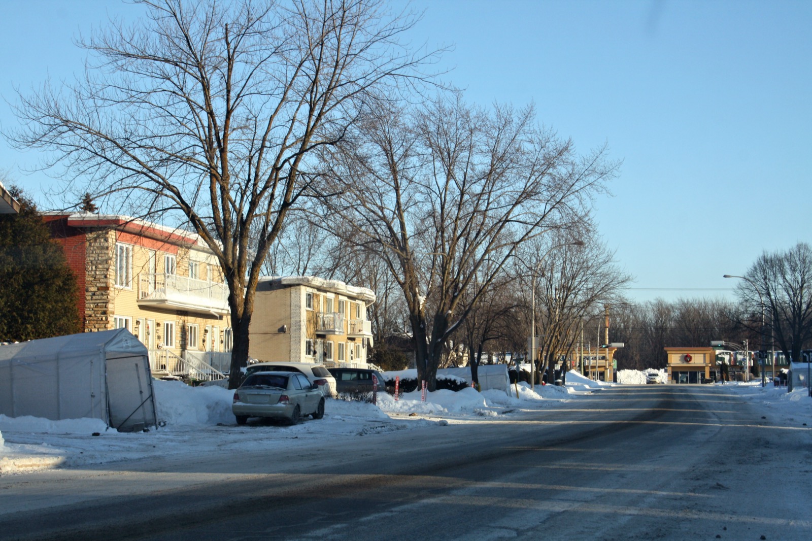 Rue résidentielle de Boisbriand en hiver, maisons et duplex des années 1960 et 1970