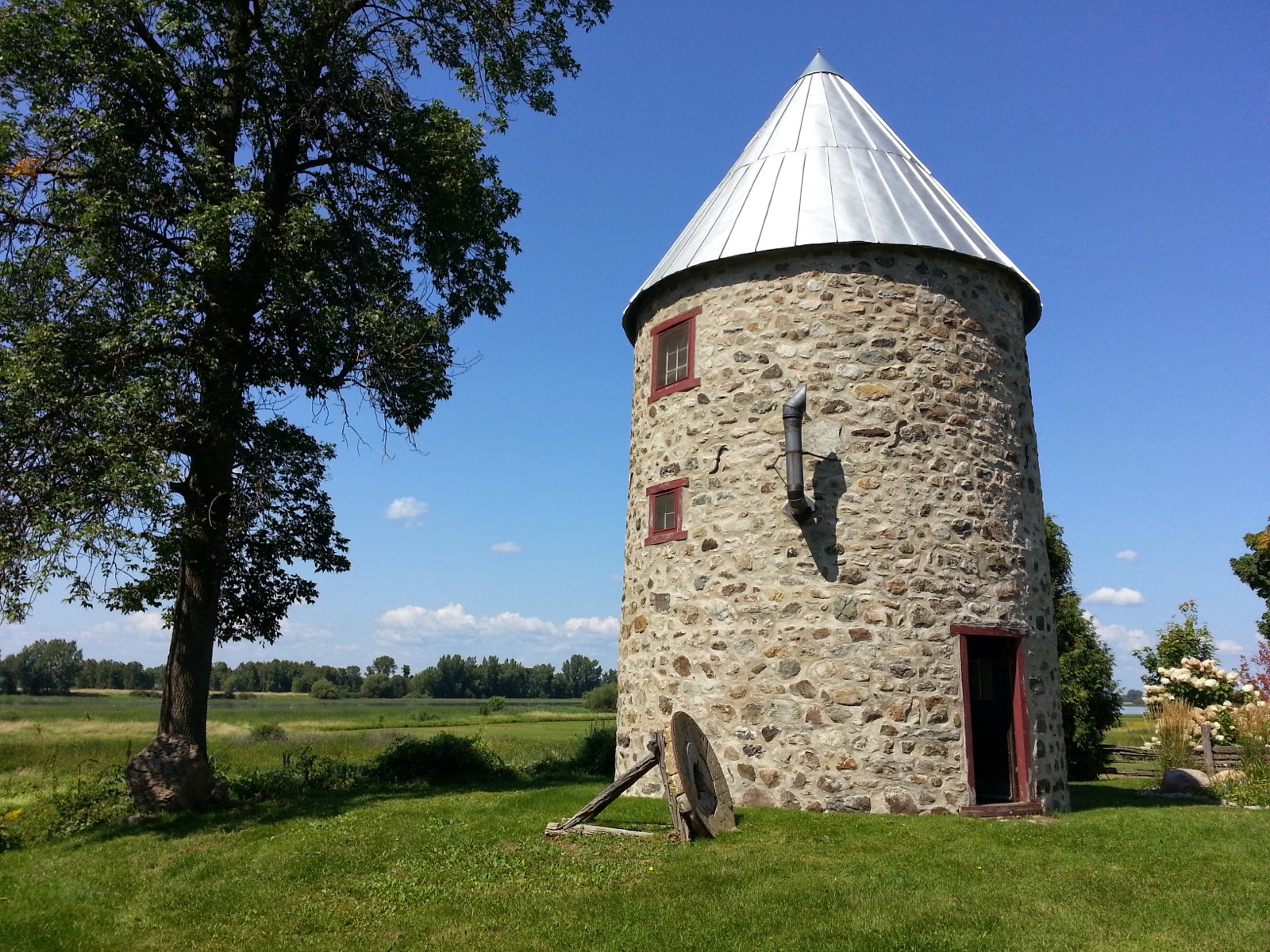 Le moulin Chaput de Contrecœur, moulin à vent en pierre des champs coiffé d'un toit conique, dans un parc riverain