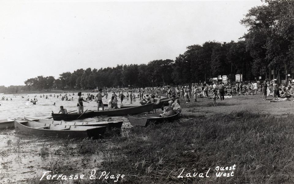 Carte postale des années 1940 montrant la terrasse et la plage de Laval-Ouest, remplie de baigneurs et de chaloupes
