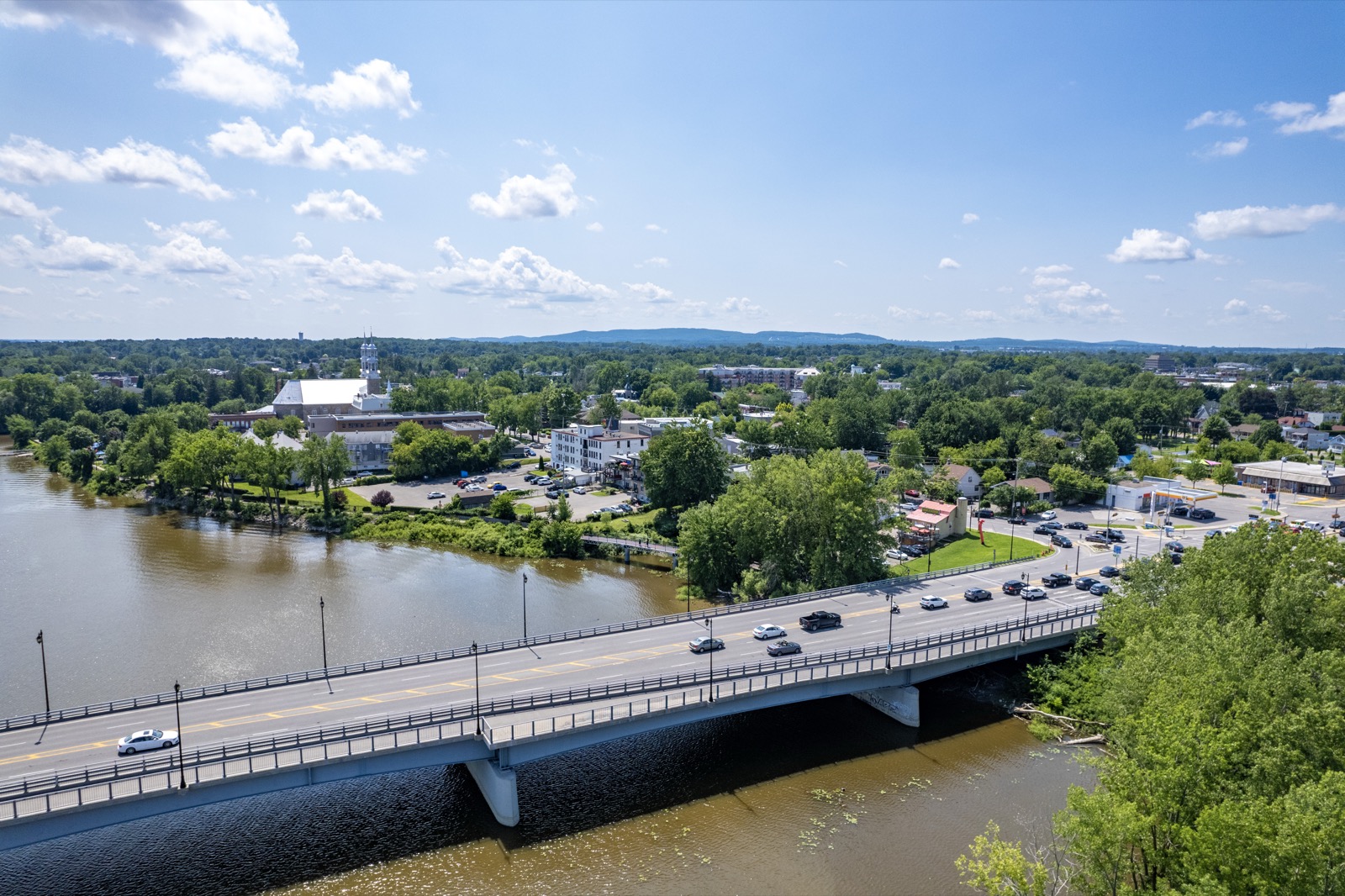 Le pont Arthur-Sauvé au-dessus de la rivière des Mille Îles, avec le vieux Saint-Eustache et les Laurentides à l'horizon