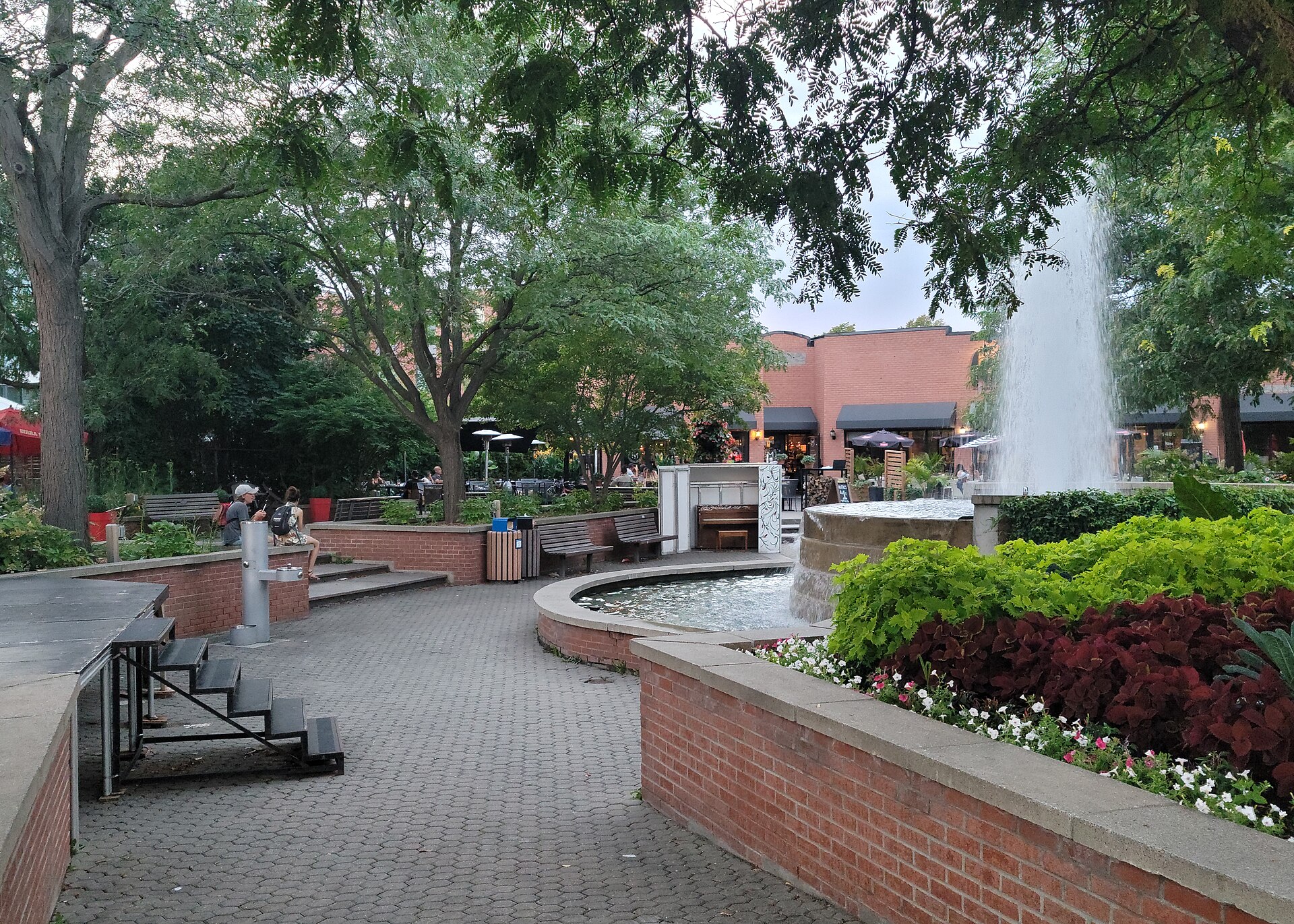 La place du Village, sa fontaine et ses terrasses au coin des rues De La Rabastalière et de Montarville