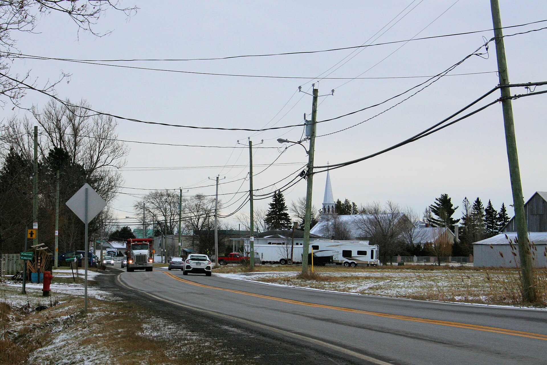 L'entrée du village de Saint-Mathieu en hiver, avec le clocher de l'église au loin
